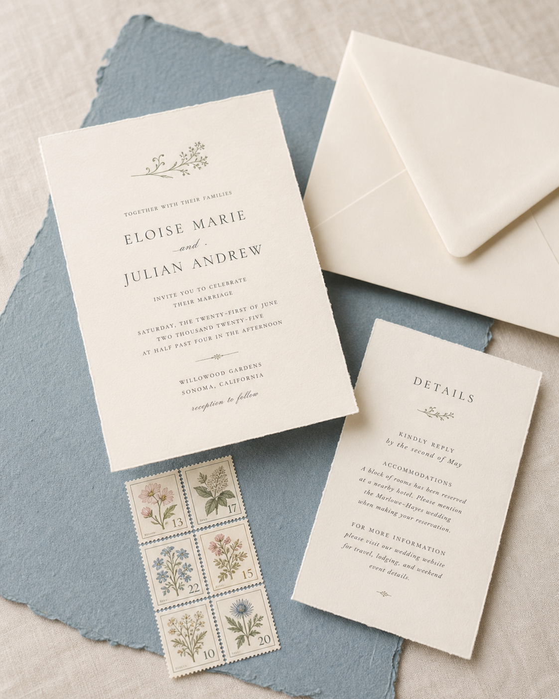 A complete wedding invitation suite with botanical postage stamps on a linen tabletop